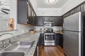 Austin apartment for rent - A modern kitchen with black cabinets and stainless steel appliances.