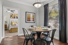 Austin apartment for rent - A dining room with a table set for two and a view of a bedroom through the window.