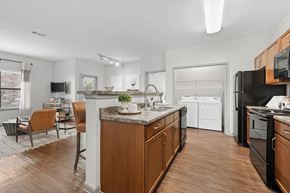 Katy apartment for rent - A modern kitchen with wooden cabinets and black appliances.
