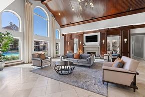 Houston apartment for rent - A large, well-furnished living room with a fireplace and a television.