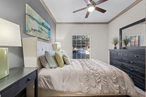Houston apartment for rent - A bedroom with a large bed and a ceiling fan.