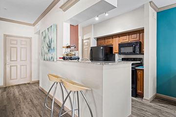 Houston apartment for rent - A kitchen with a white counter and bar stools.