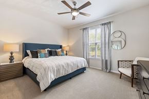Spring apartment for rent - A bedroom with a large bed and a ceiling fan.