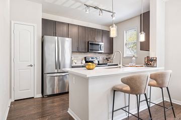 Spring apartment for rent - A kitchen with a white counter and a refrigerator.