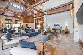 Spring apartment for rent - A large, open-concept living room with a high ceiling and exposed beams.
