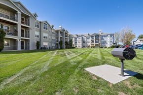 Broomfield apartment for rent - A mailbox sits on a concrete slab in front of a grassy area with apartment buildings in the background.