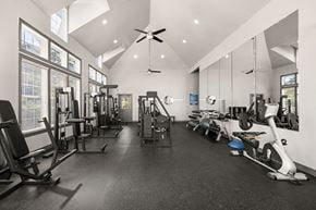 Broomfield apartment for rent - A spacious gym with a variety of equipment and mirrors on the wall.