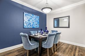 Houston apartment for rent - A dining room with a wooden table and blue chairs.