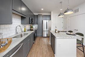 Norcross apartment for rent - a large kitchen with stainless steel appliances and gray cabinets