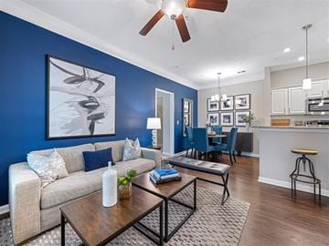 Charlotte apartment for rent - A living room with a blue wall and a painting of a bird.