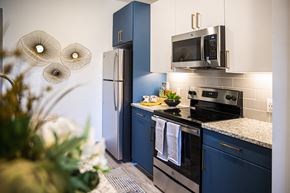 Atlanta apartment for rent - A kitchen with a blue refrigerator and a black stove top oven.