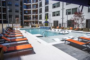 Atlanta apartment for rent - A pool area with sun loungers and a building in the background.