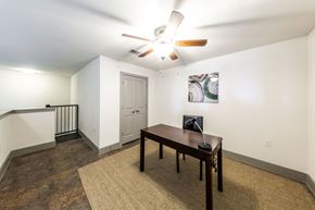 Austin apartment for rent - A room with a ceiling fan and a table with a laptop on it.