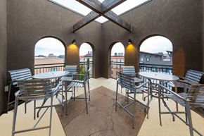 Austin apartment for rent - A patio with chairs and tables is surrounded by buildings.