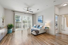 Austin apartment for rent - A bedroom with a bed, a plant, and a painting on the wall.