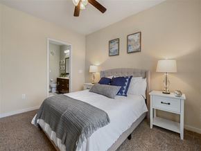 Austin apartment for rent - A bedroom with a bed, nightstand, and ceiling fan.