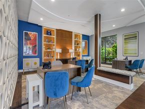 Austin apartment for rent - A modern dining room with blue chairs and a wooden table.