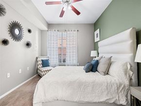 Dallas apartment for rent - A bedroom with a large bed and a ceiling fan.
