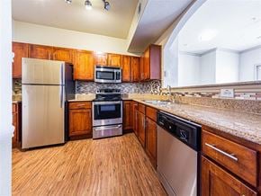 Richmond apartment for rent - A kitchen with wooden cabinets and stainless steel appliances.