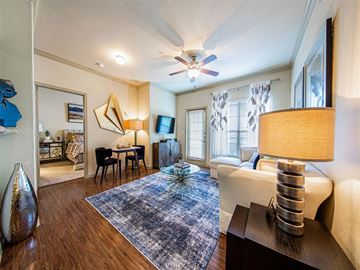 Richmond apartment for rent - A living room with a blue rug and a ceiling fan.