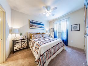 Richmond apartment for rent - A bedroom with a bed, nightstand, and a ceiling fan.