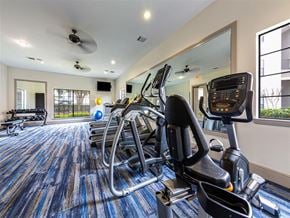 Richmond apartment for rent - A gym with a row of exercise bikes and a mirror on the wall.