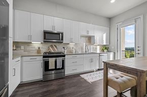 Austin apartment for rent - A modern kitchen with white cabinets and a wooden island.