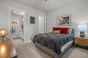Austin apartment for rent - A bedroom with a bed, nightstand, and a lamp.