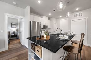 Leander apartment for rent - a kitchen with white cabinets and a black counter top
