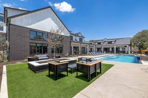 Austin apartment for rent - a yard with tables and chairs and a pool in front of a building
