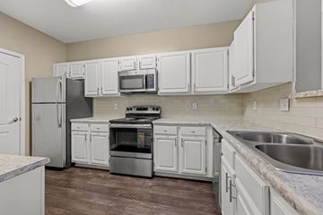Atlanta apartment for rent - A kitchen with white cabinets and stainless steel appliances.