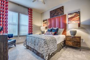 Roanoke apartment for rent - A bedroom with a bed, a chair, and a painting on the wall.