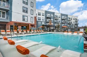 Roanoke apartment for rent - A swimming pool with orange chairs and a fountain in the middle.