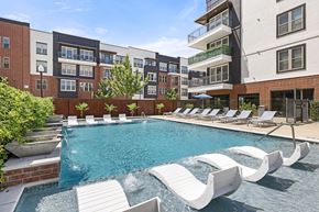 Roanoke apartment for rent - A pool with a slide and lounge chairs in front of apartment buildings.