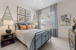 Roanoke apartment for rent - A bedroom with a large bed, a nightstand with a lamp, and a painting on the wall.