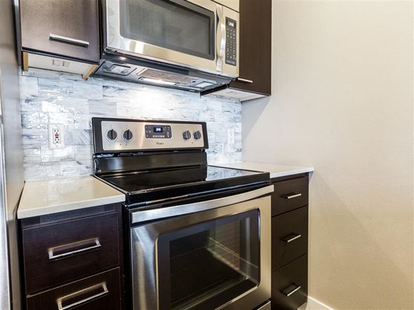 Seattle apartment for rent - A black stove top oven with a digital display is in a kitchen.