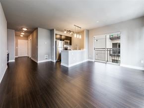 Seattle apartment for rent - A spacious room with wooden floors and white walls.