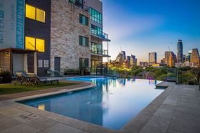 Austin apartment for rent - an apartment pool with a city skyline in the background