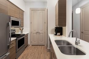 Houston apartment for rent - A modern kitchen with a stainless steel sink and wooden cabinets.
