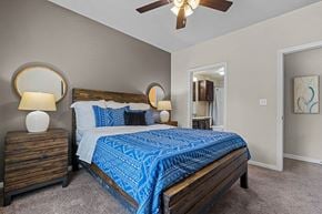 Plano apartment for rent - a bedroom with a bed and a ceiling fan