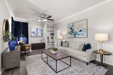 Fort Worth apartment for rent - A living room with a white couch, a coffee table, and a painting on the wall.