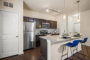 Austin apartment for rent - A kitchen with a white counter top and blue chairs.