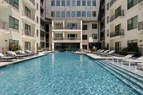 Austin apartment for rent - A large indoor swimming pool with lounge chairs on the side.