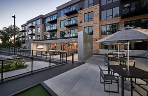 Minnetonka apartment for rent - a patio with tables and umbrellas in front of a building