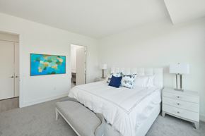 Minnetonka apartment for rent - a white bedroom with a large bed and a blue painting on the wall