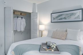 Hialeah apartment for rent - a bedroom with a bed and a closet with clothes hanging on it