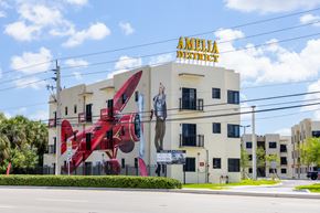 Hialeah apartment for rent - a building with a mural of a red plane on the side of it