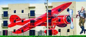 Hialeah apartment for rent - a mural of a red plane on the side of a building