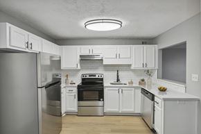 Atlanta apartment for rent - A modern kitchen with white cabinets and stainless steel appliances.