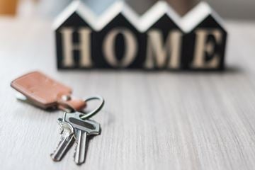 Daytona apartment for rent - A set of keys and a wallet are placed in front of a HOME sign.